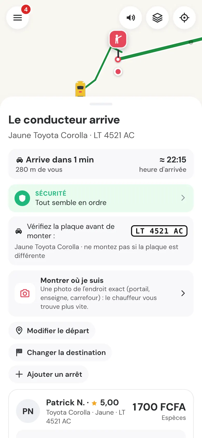 Écran « Le conducteur arrive » : arrivée dans 1 min, bandeau Sécurité « Tout semble en ordre », plaque LT 4521 AC à vérifier avant de monter, « Montrer où je suis ».